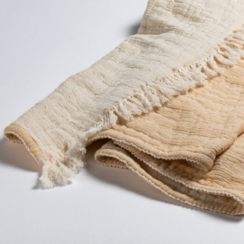 Baumwollplaid "Garda" von Evelyn Kahle: Das moderne Baumwollplaid im Knitter-Look in Beige/Gelb ist eine stilvolle Decke.