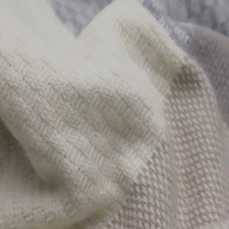 Nahaufnahme der Merinowolle Kuscheldecke mit Zierstich-Einfassung und mehrfarbigem Gewebe
