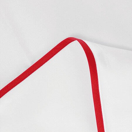 Perkal-Paspel-Bettwäsche von Evelyn Kahle, elegantes Weiß mit roter Satin-Paspel, edles Schlafzimmer mit Farbakzent.