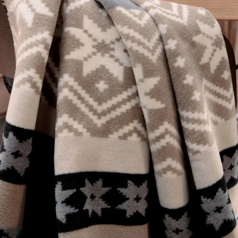 Detailaufnahme der Kuscheldecke Winter Braid mit flauschiger Struktur und Schneeflockenmotiv.