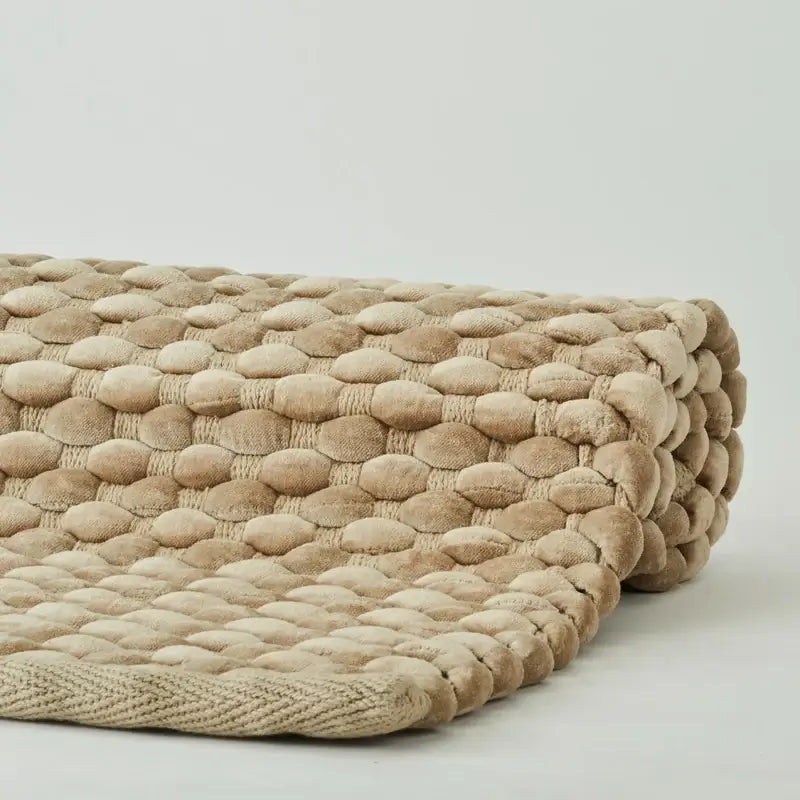 Badteppich Maks von Aquanova in Almond Hellbraun, Detailaufnahme der noppenartigen Struktur und eingefassten Kante
