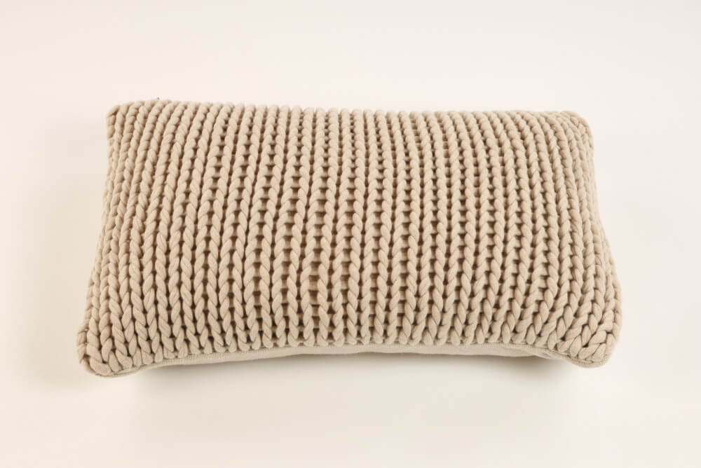 Grobe Strickstruktur: Der Kissenbezug Mancheste in Beige mit grober Strickstruktur bringt Gemütlichkeit in Ihren Wohnraum.