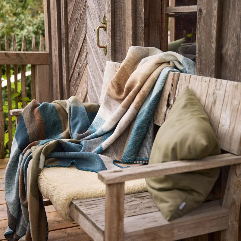 Kuscheldecke Iceland Horizon als Sofadecke auf einer Bank im Outdoor-Wohnbereich