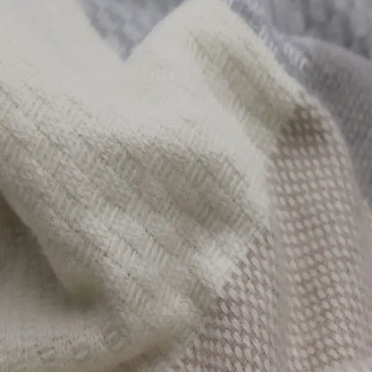 Nahaufnahme der Merinowolle Kuscheldecke mit Zierstich-Einfassung und mehrfarbigem Gewebe