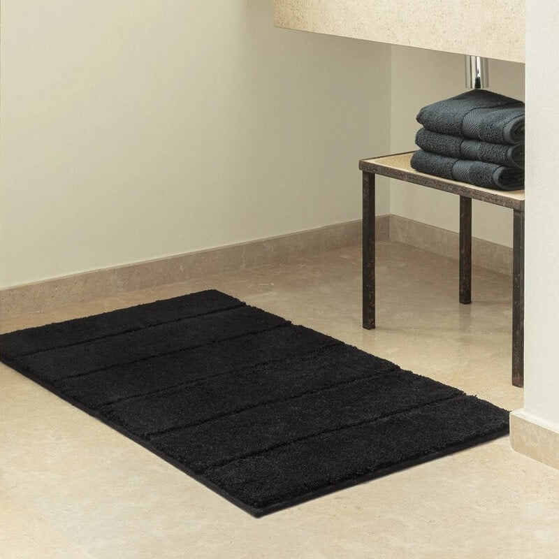 Pflegeleichter Badteppich Ray Schwarz mit markanten, breiten Hoch-Tief-Streifen und rutschfester Unterseite für moderne Eleganz.