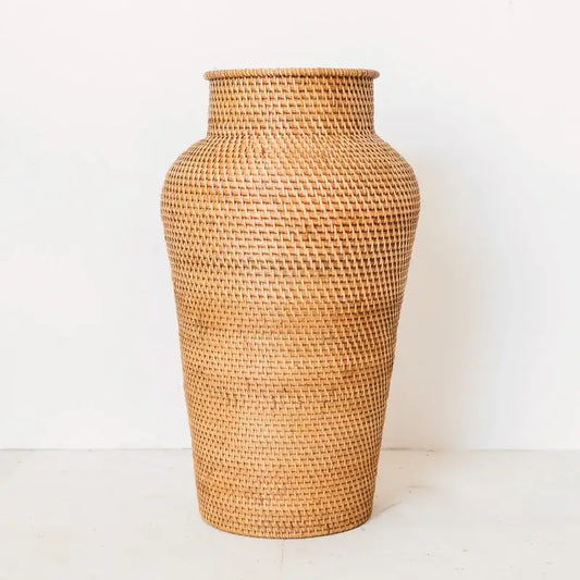 Große Rattan-Bodenvase Kidung vor weißer Wand, handgefertigt aus Naturmaterial.