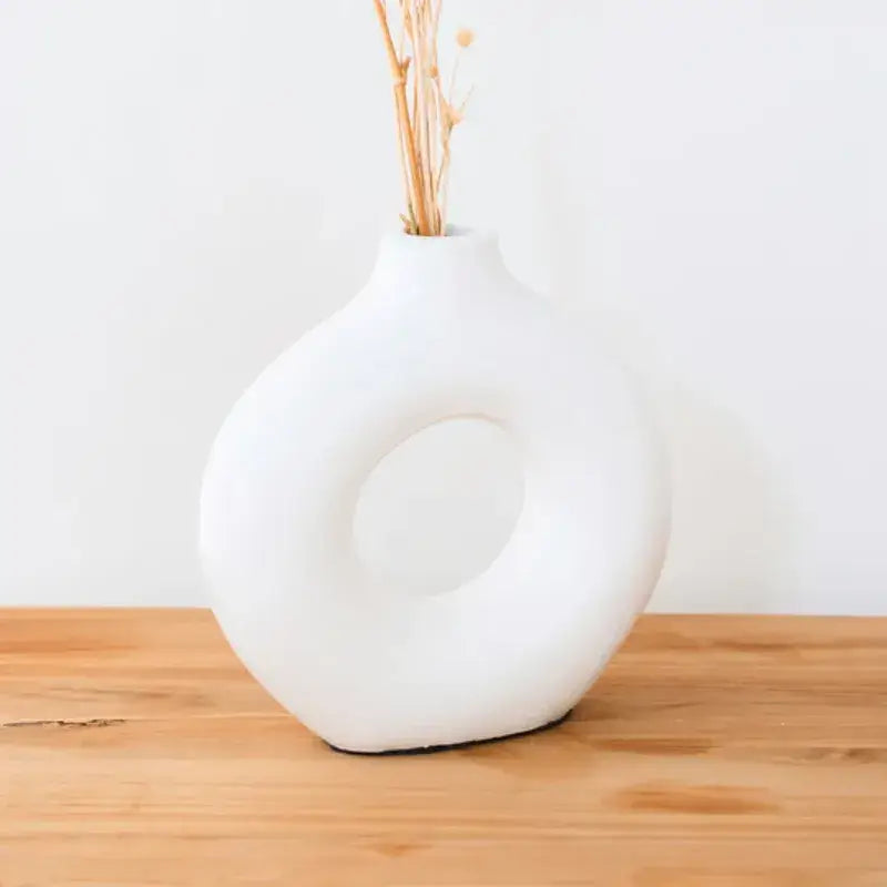 Tonvase Nusa in eleganter Ringform mit Trockenblumen auf Holzoberfläche.