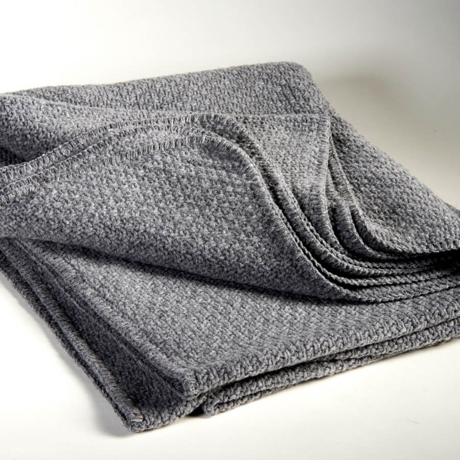 Strickdecke in Dunkelgrau: Die Strickdecke "Oslo" von Evelyn Kahle in Dunkelgrau mit Strickoptik ist ein kuscheliges Wohnaccessoire.