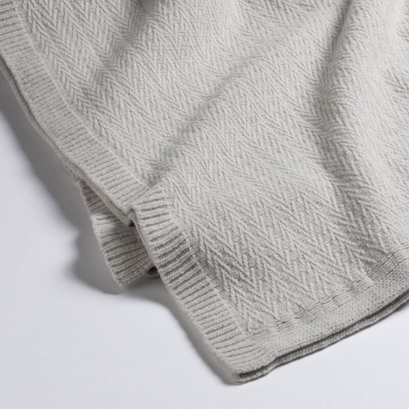 Wolldecke "Luzern" von Evelyn Kahle: Das moderne Plaid mit Zickzack-Muster in Grau ist eine stilvolle Decke.